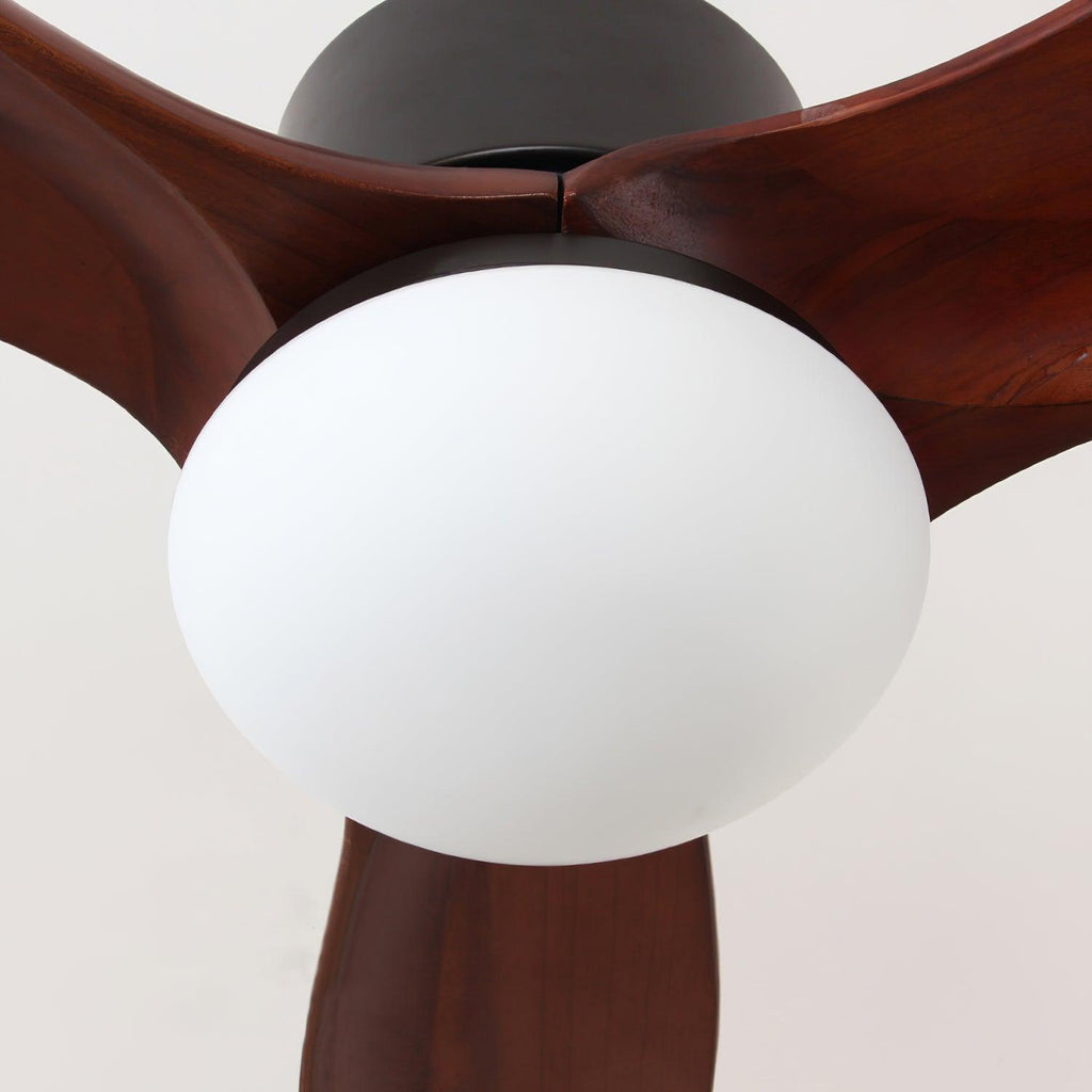 Close view of the white frosted light shade under the black motor on this Clérachic ceiling fan, framed by dark blades.