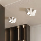 Two Clérachic white square-section ceiling lights with angled lit faces above a dark shelving unit
