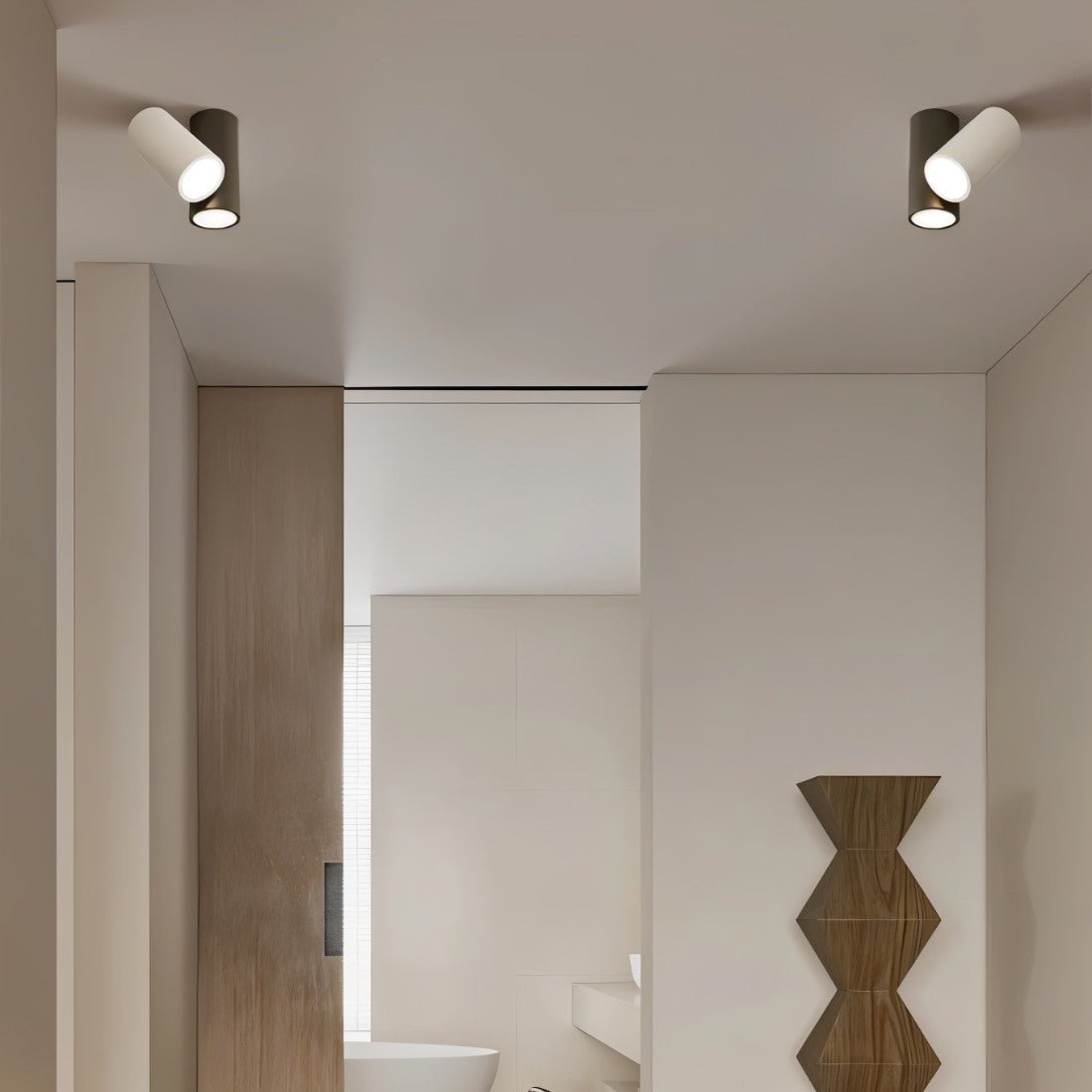 Pair of Clérachic ceiling lights, each a white and a dark cylinder, in a hallway beside a wooden door