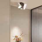 Clérachic square-section ceiling light with a dark centre block and white heads, above a vase of dried flowers