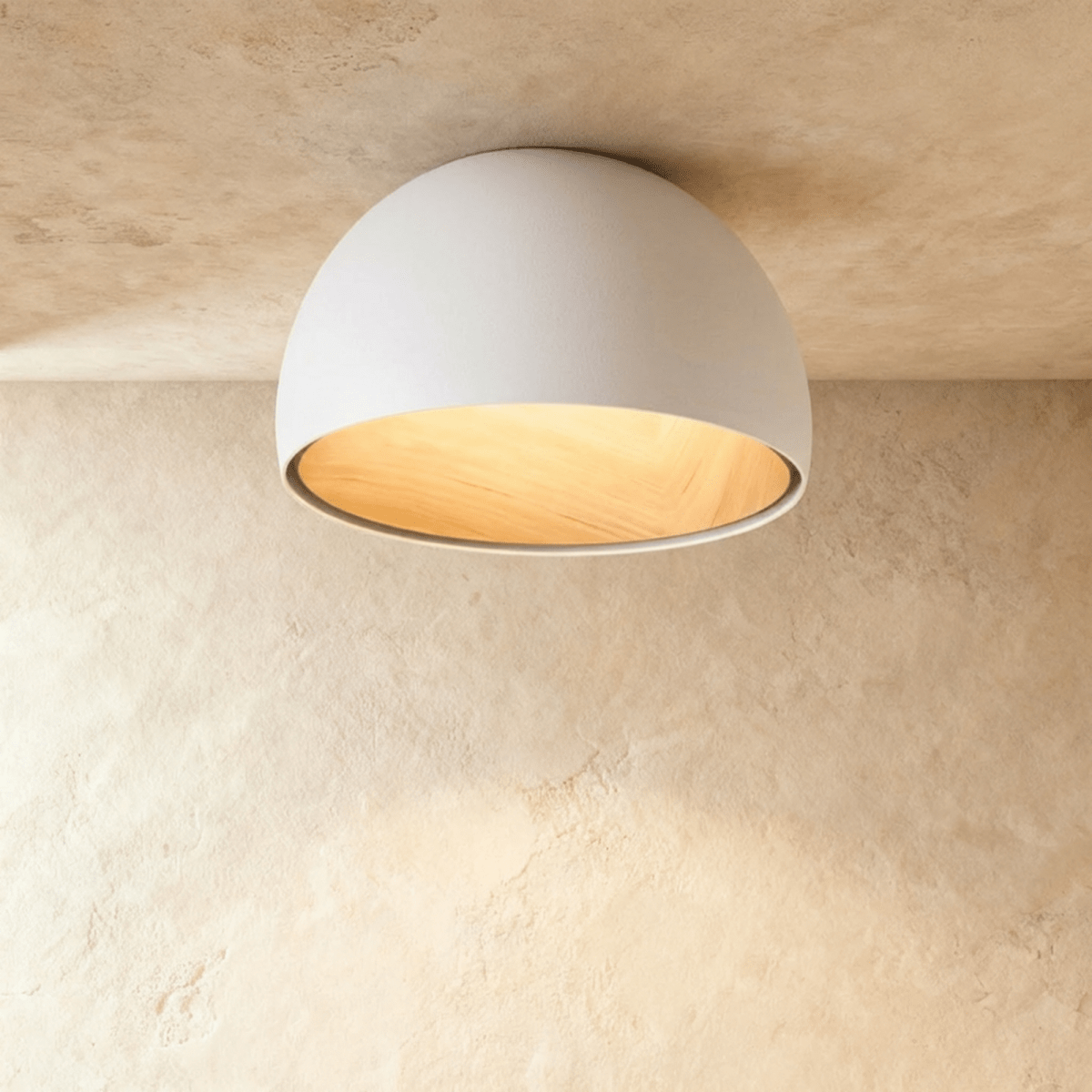Clérachic white domed ceiling light with a glowing wood-grain interior, mounted flush against a limewashed ceiling.