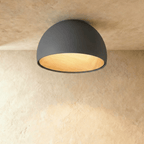 Clérachic grey domed ceiling light with a warm wood-grain interior, seen from below against a limewashed ceiling.