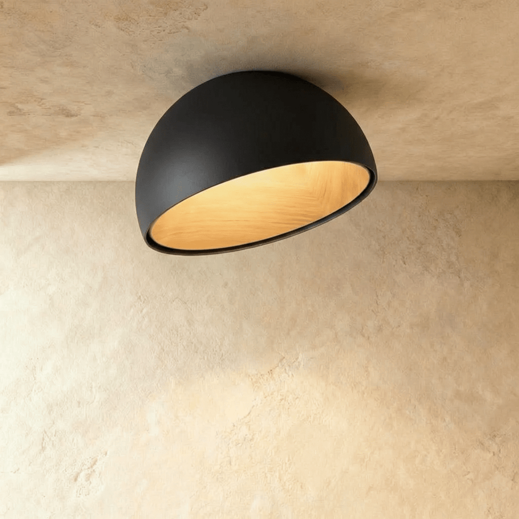 Clérachic black ceiling light with an angled, slanted-cut dome and a warm wood-grain interior on a limewashed ceiling.