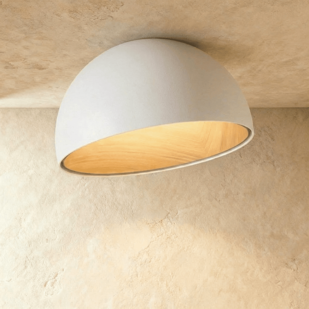 Clérachic larger white angled-dome ceiling light with a wide, glowing wood-grain interior on a limewashed ceiling.