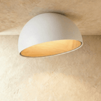 Clérachic larger white angled-dome ceiling light with a wide, glowing wood-grain interior on a limewashed ceiling.
