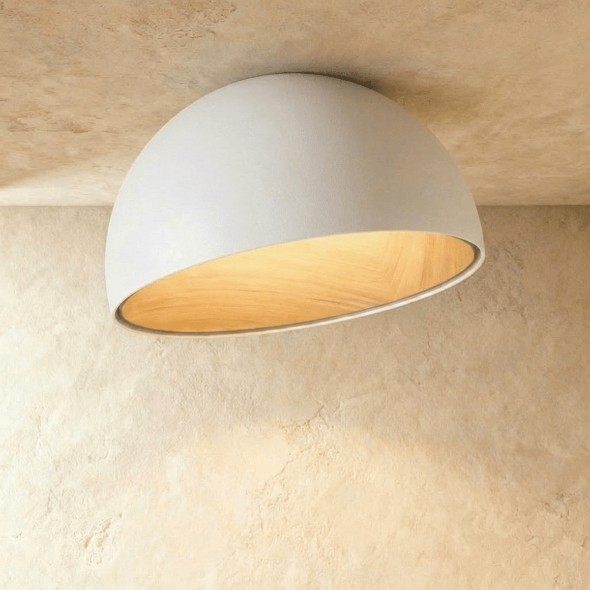 Clérachic larger white angled-dome ceiling light with a wide, glowing wood-grain interior on a limewashed ceiling.