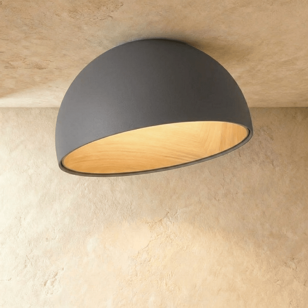 Clérachic larger grey angled-dome ceiling light with a wide, glowing wood-grain interior on a limewashed ceiling.