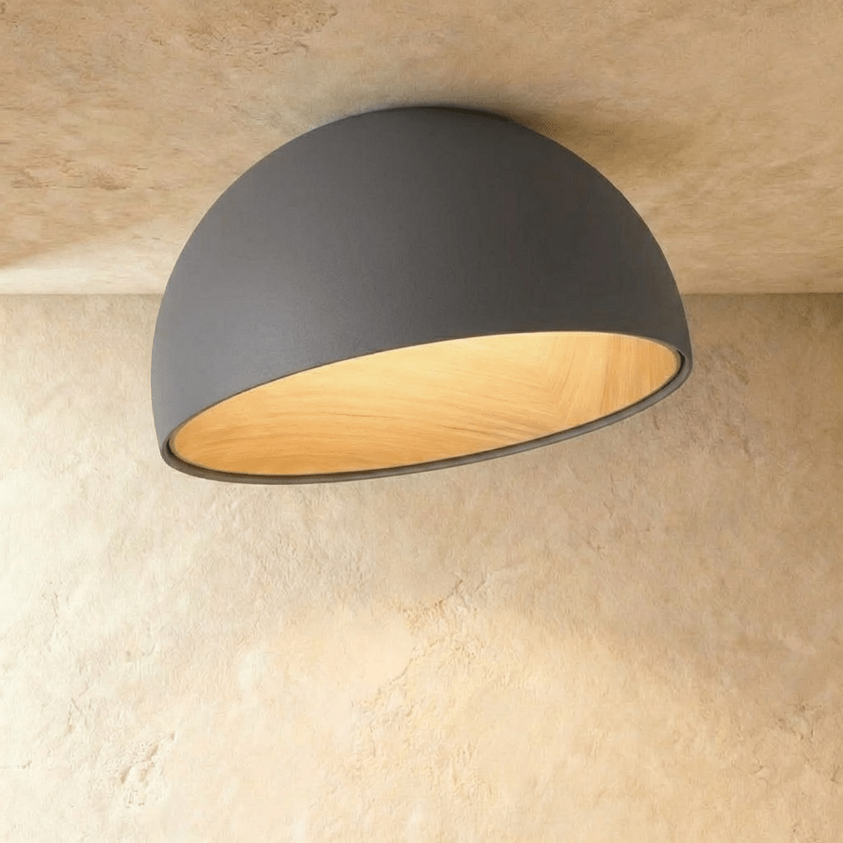 Clérachic larger grey angled-dome ceiling light with a wide, glowing wood-grain interior on a limewashed ceiling.