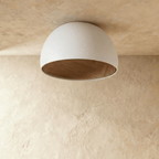 Clérachic white domed ceiling light switched off, showing the natural wood-grain lining inside its matt shade.