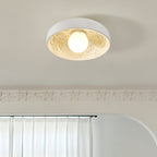 Clérachic white bowl light lit under a carved ceiling cornice, with a curtain rail and a rounded archway below.