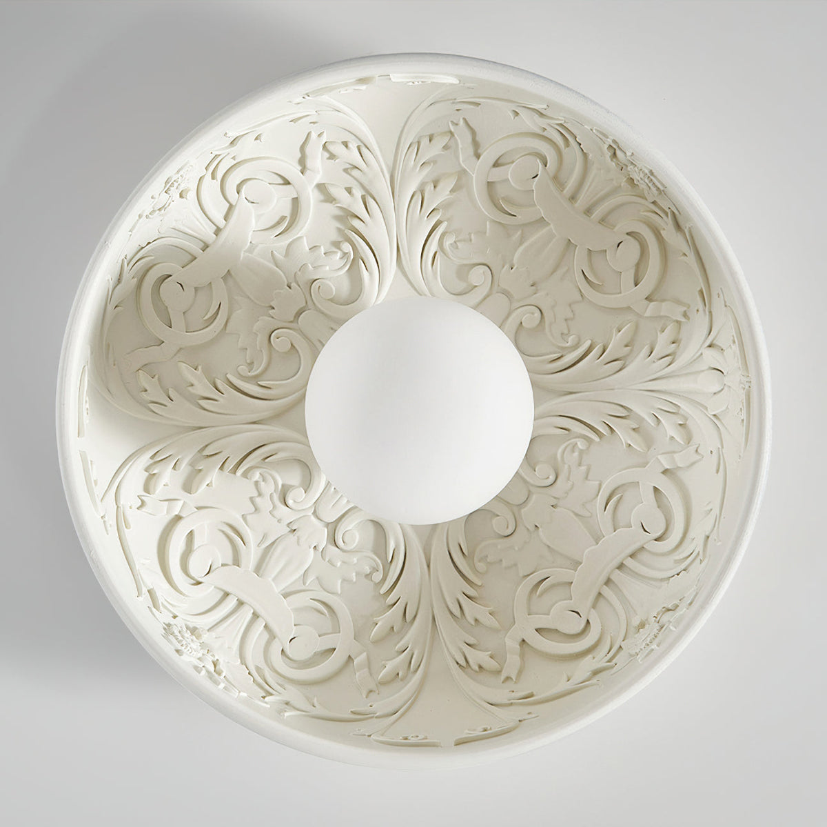 Looking straight up into this Clérachic bowl light, its carved acanthus-style relief radiating around the white globe.