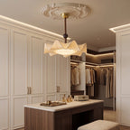 In a walk-in wardrobe with a plaster ceiling rose, this Clérachic ceiling light hangs above a walnut island.