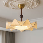 Close view of the lit diffuser and the scalloped cream shade of this Clérachic ceiling light under a decorated ceiling.