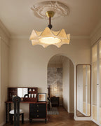 A Clérachic ceiling light seen from across a bedroom with an arched doorway, a dark dressing table and a tall mirror.