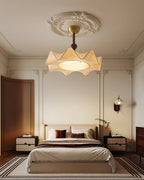This Clérachic ceiling light hangs under a plaster ceiling rose, above a bed with striped rug and two cream bedside tables.