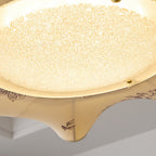 Close view of the frosted, speckled glass diffuser and the leaf print at the edge of this Clérachic ceiling light.