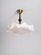 Clérachic ceiling light unlit against a plain grey ceiling, with a brass canopy and a softly pleated cream shade.