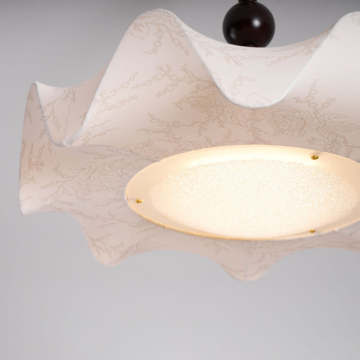 Close view of the glowing diffuser and fine botanical pattern on the cream shade of this Clérachic ceiling light.