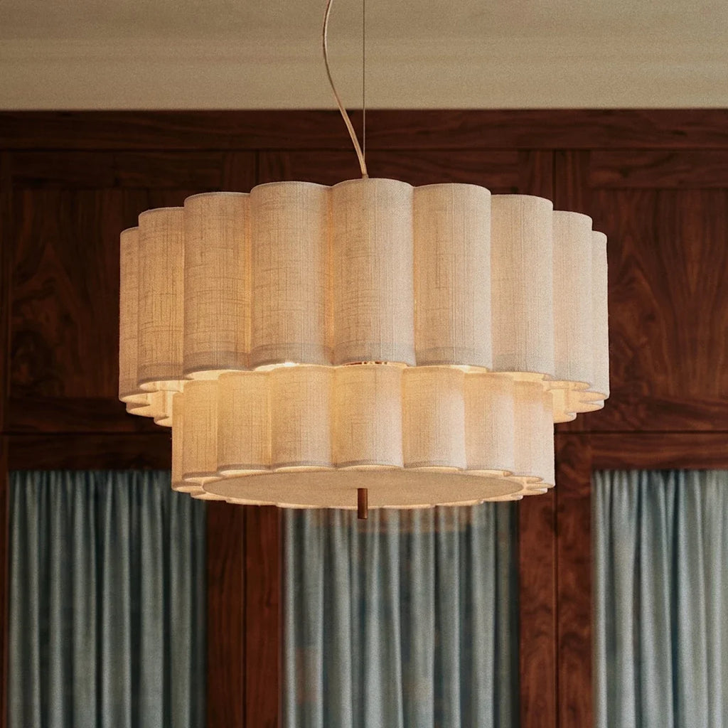 A Clérachic pendant light glows warmly in a wood-paneled room, its fluted shade bright against dark walnut.