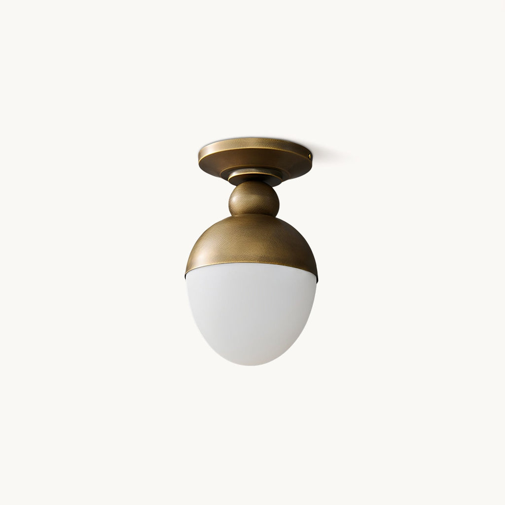 Antique brass cap and ball joint above a frosted white glass globe, this Clérachic ceiling light is shown on a plain white backdrop.