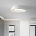 White low-profile dome ceiling light from Clérachic in a grey room with framed line drawings and a white wardrobe.
