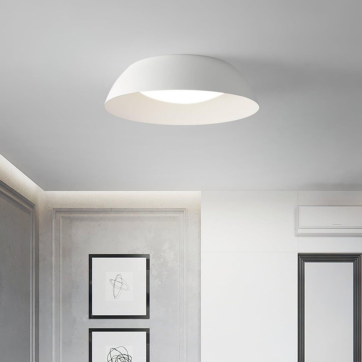 White low-profile dome ceiling light from Clérachic in a grey room with framed line drawings and a white wardrobe.