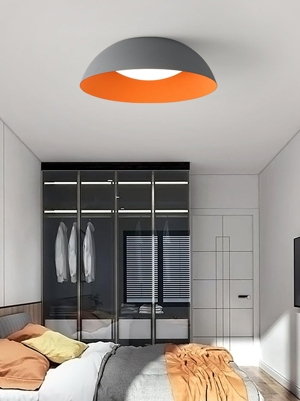 Grey dome with orange interior from Clérachic hung above a bedroom with a glass-fronted wardrobe and orange bedding.