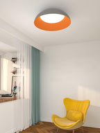 Grey and orange Clérachic ceiling light above a white room with a teal curtain and a yellow wing chair.
