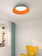 Grey and orange Clérachic ceiling light above a corner with a teal curtain, sheer voile and a yellow armchair.
