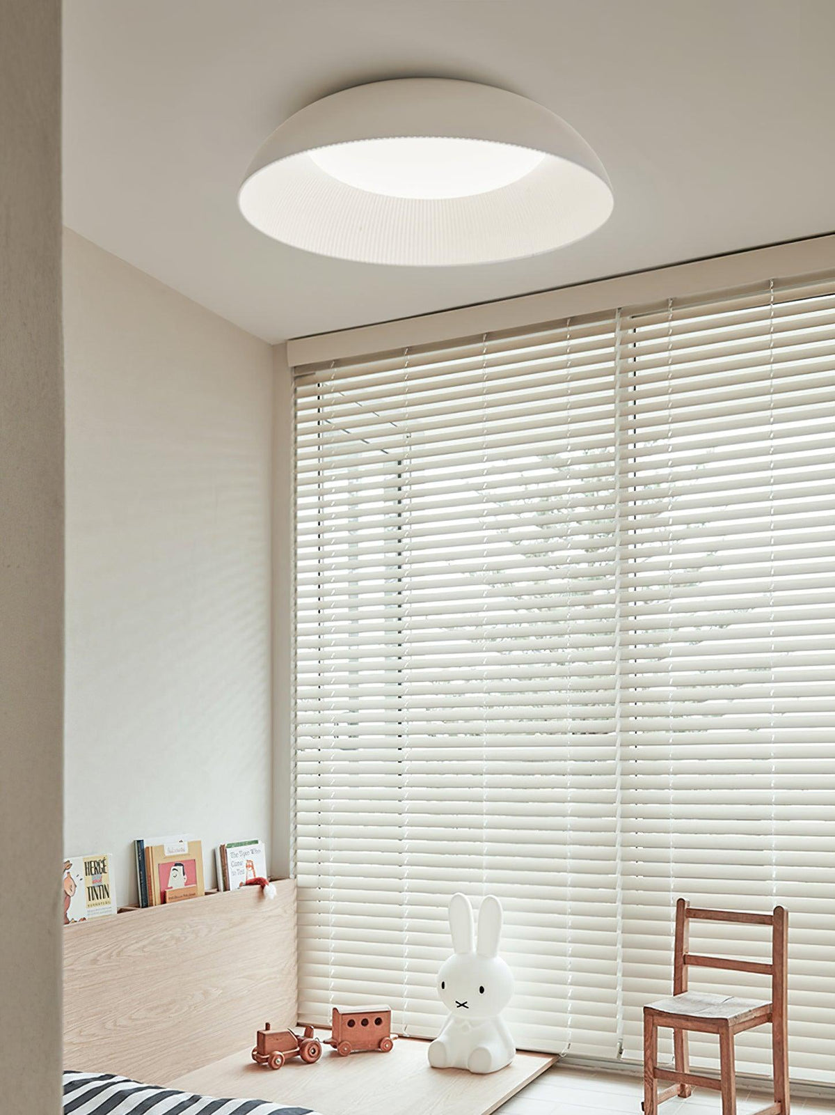 White dome ceiling light from Clérachic above a child-friendly room with venetian blinds, a small wooden chair and a rabbit lamp.