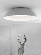 Wide white dome of this Clérachic ceiling light with its ribbed white interior, shown against a textured grey wall with a stag print.