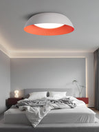 White dome with an orange interior above a low grey bed with a glowing bedside lamp, a Clérachic ceiling light in a calm bedroom.