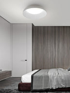 Pale dome ceiling light from Clérachic with a bright white diffuser above a bed, with a slatted wood wall and a dark-red base.