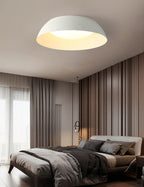 White dome ceiling light with a warm-lit interior above a bed in a taupe bedroom with striped curtains, from Clérachic.