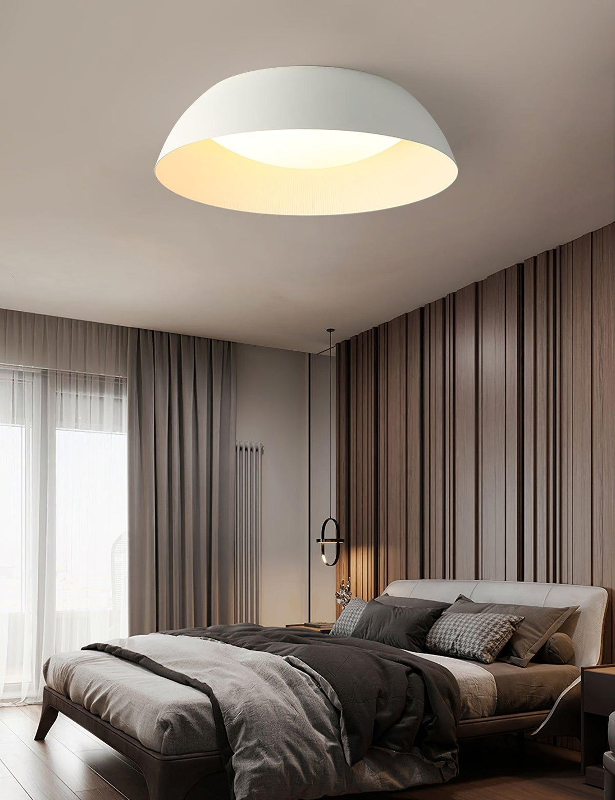 White dome ceiling light with a warm-lit interior above a bed in a taupe bedroom with striped curtains, from Clérachic.