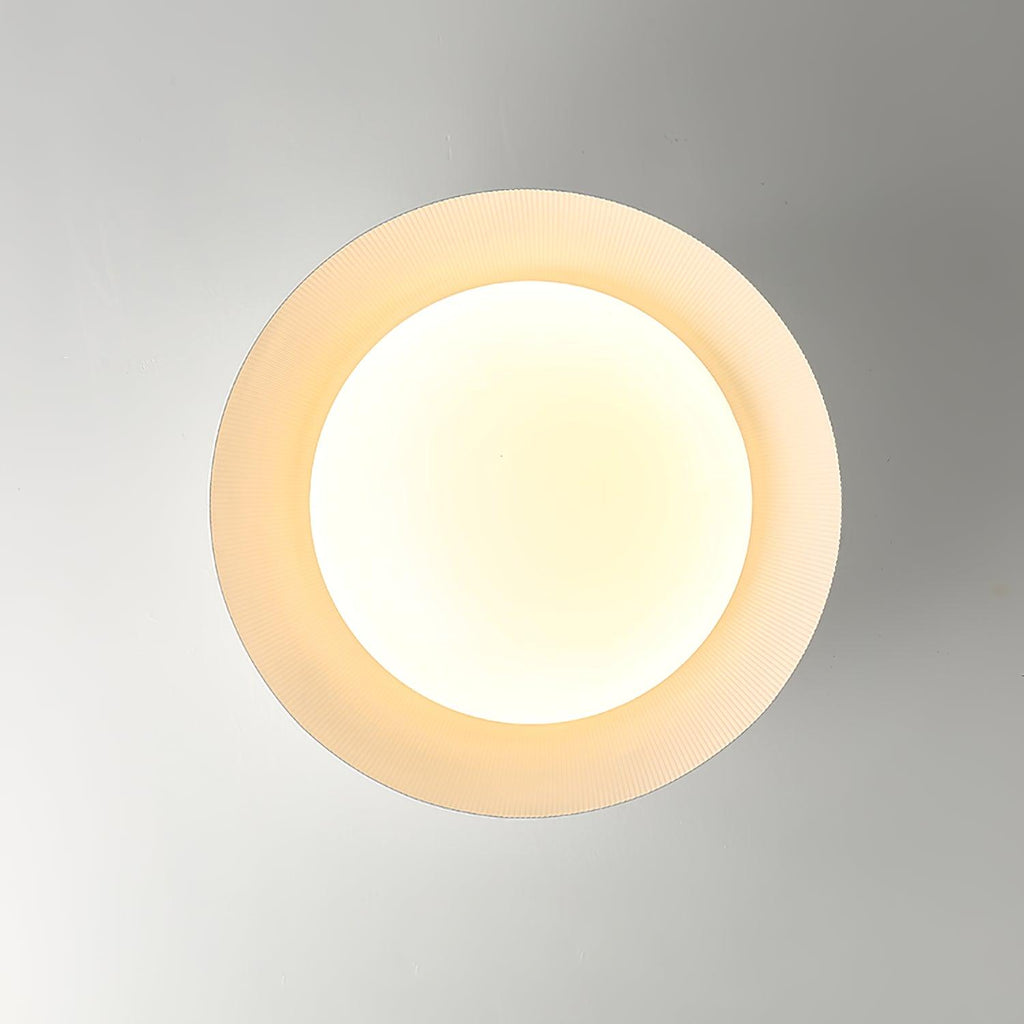 Looking straight up at the white ribbed ring and warm round diffuser of this Clérachic ceiling light.