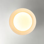 Looking straight up at the white ribbed ring and warm round diffuser of this Clérachic ceiling light.