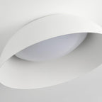 Close view of the white outer edge, ribbed interior and curved diffuser of this Clérachic ceiling light, seen from below.
