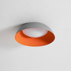 Grey and orange Clérachic ceiling light seen slightly from below, its white diffuser visible inside the dome.