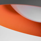 Close view of the grey rim, ribbed orange inside and white diffuser on this Clérachic ceiling light.