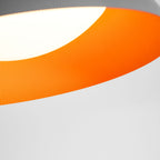 Detail of the orange-ribbed interior and curved white diffuser of this Clérachic ceiling light, with the grey rim above.