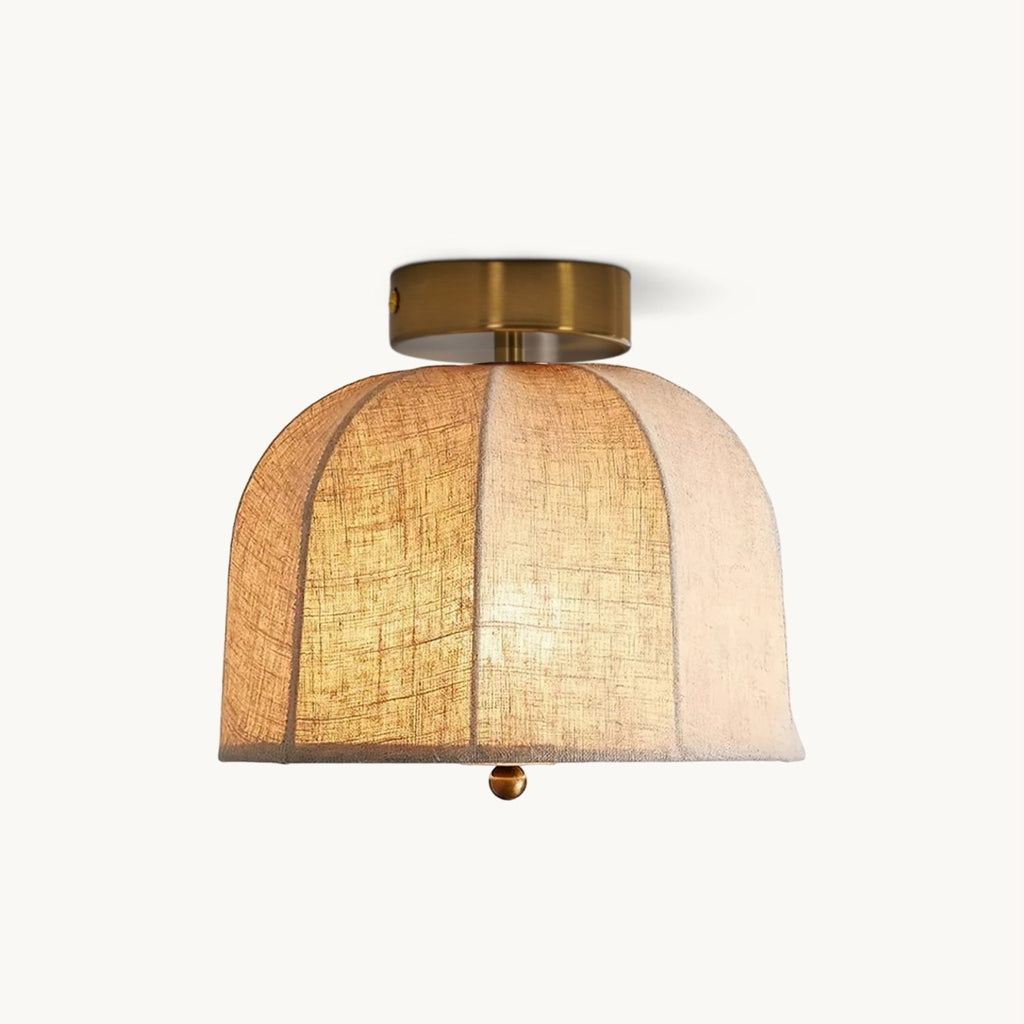 A wide Clérachic flush-mount ceiling light with a ribbed natural linen shade and a gold-finish canopy, lit on a white backdrop.