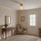 A small Clérachic flush-mount light with a linen shade hangs in an entrance room with floral wallpaper, a console table and a white door.