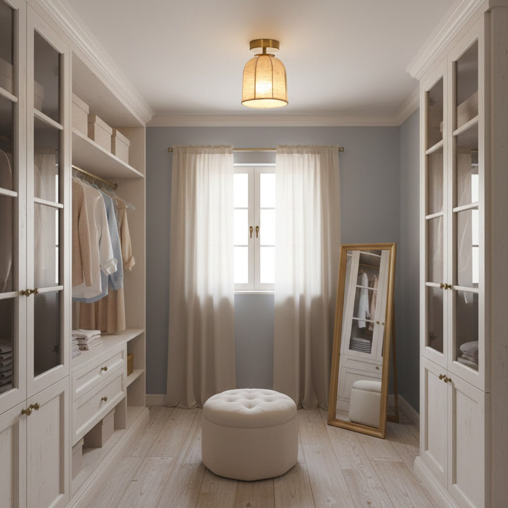 Clérachic linen-shade ceiling light in a walk-in wardrobe with glass-fronted cupboards, a round pouffe and a tall mirror by a curtained window.
