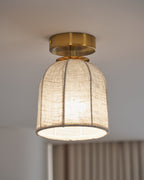 Clérachic flush-mount light with an unlit-looking linen shade and a beaded lower edge, hung beside a striped curtain.