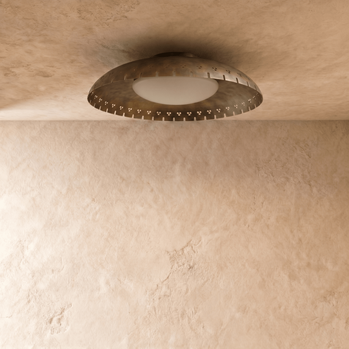 Clérachic ceiling light in vintage brass viewed from another angle, its slotted rim glowing softly overhead.