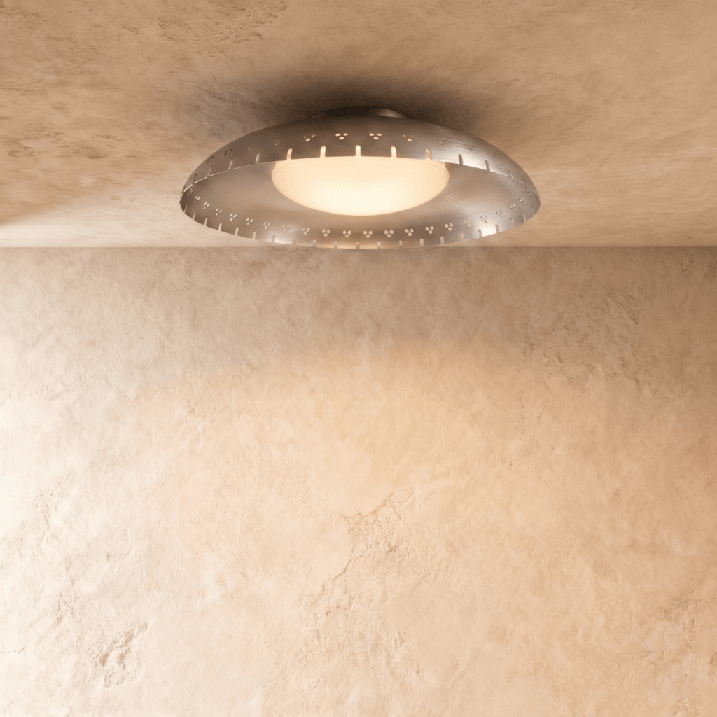 Clérachic ceiling light in chrome, its slotted metal rim reflecting soft light on a plaster ceiling.
