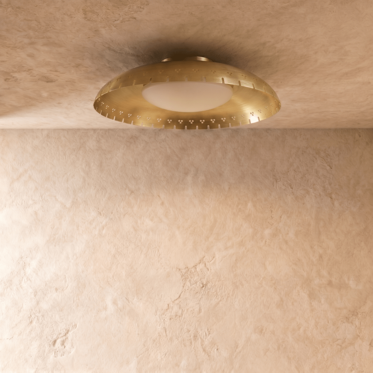Clérachic ceiling light in brushed brass shown close, the frosted glass diffuser glowing beneath the rim.