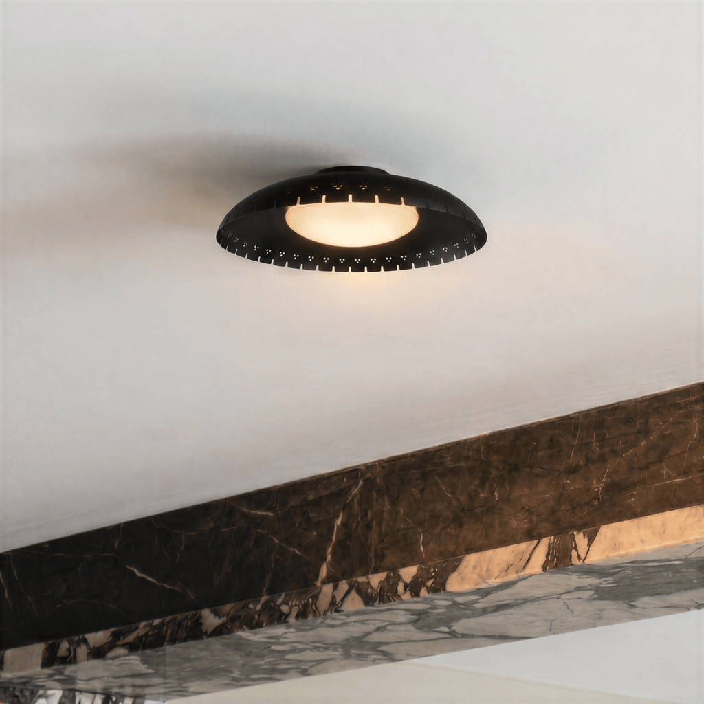 Clérachic ceiling light in matte black mounted beside a veined marble ledge in a minimalist interior.
