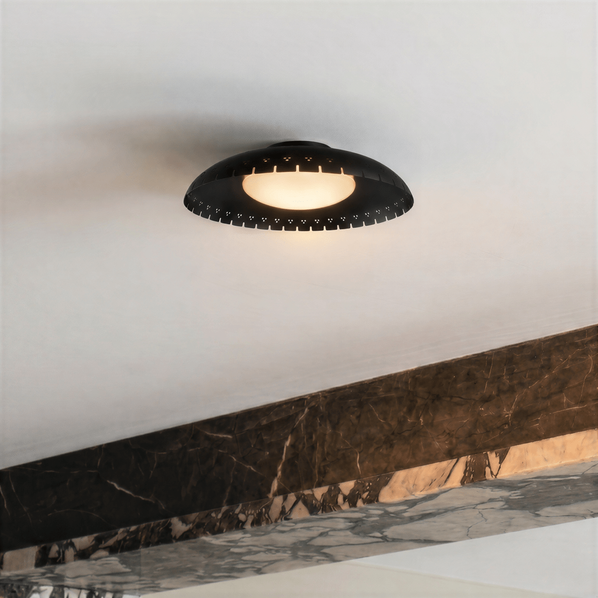Clérachic ceiling light in matte black mounted beside a veined marble ledge in a minimalist interior.